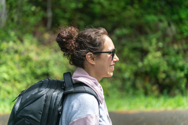 istock Young ethnic woman walking along the road with a backpack 1254898039