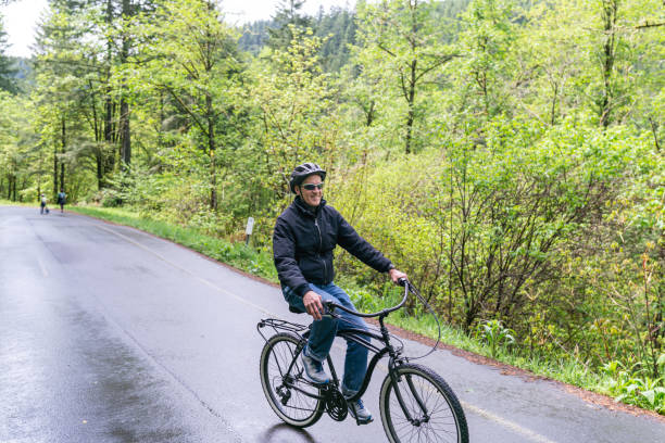 istock Senior man riding bicycle on rural road 1254898058