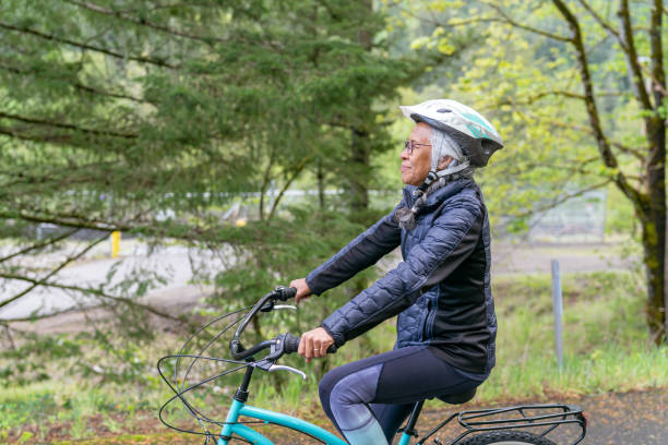 istock Senior woman riding bicycle on rural road 1254898183