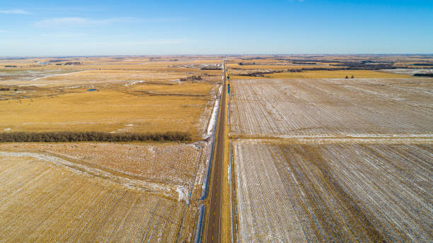 the scenic panoramic aerial view of the small highway between the harvested fields in the country farmland. the pony express historic route - us route 136 in nebraska nearby the border with kansas, central usa. - pony express imagens e fotografias de stock
