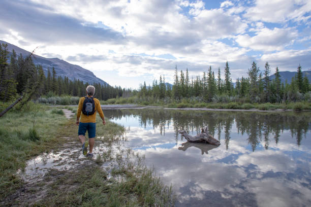 istock Man relaxes by riverbank in the morning 1254899456
