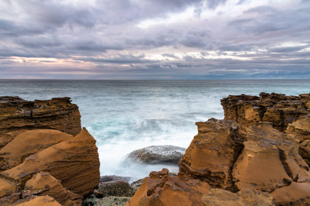 istock Rain Clouds and a Sunrise Seascape from Rock Platform 1254904999