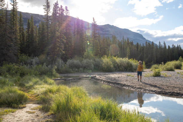 istock Man relaxes by riverbank in the morning 1254905676