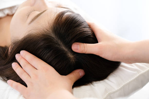 mujer que recibe un masaje en el cuero cabelludo y la mano del practicante - alternative medicine shiatsu massaging spa treatment fotografías e imágenes de stock