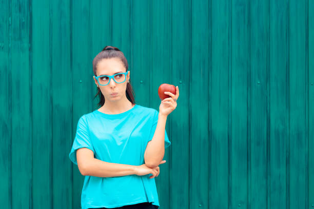 istock Curious Girl Looking at an Apple Ready to Snack 1254912354