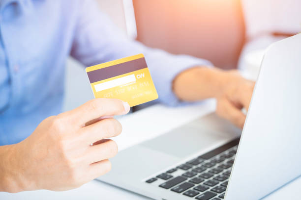 istock Hands holding credit card and using laptop. working at home. 1254920975