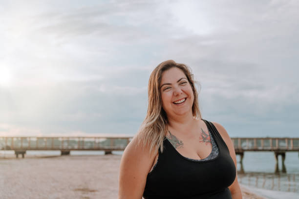 istock Latin woman smiling on the beach 1254922303