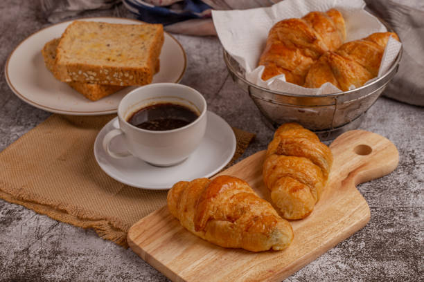 istock freshly baked croissants and whole wheat bread with black coffee on grey table for breakfast 1254923935