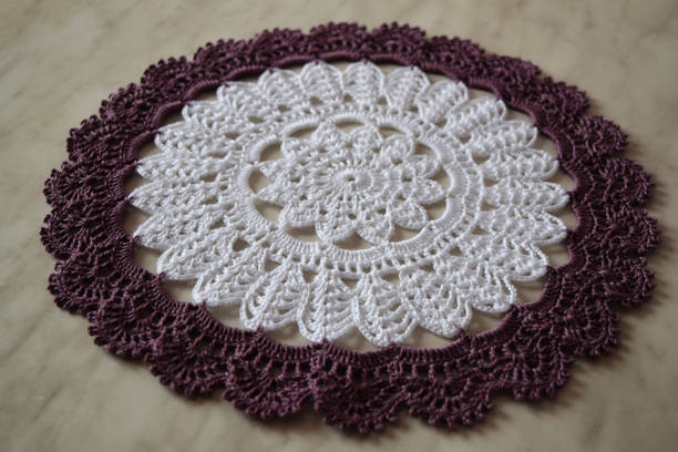 istock White and purple hand hooked coaster. Knitted holders for hot work 1254928733