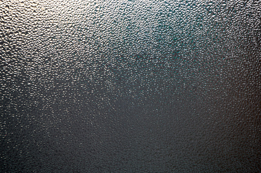 Misted glass. Condensate. Water droplets on the window. Abstract background.