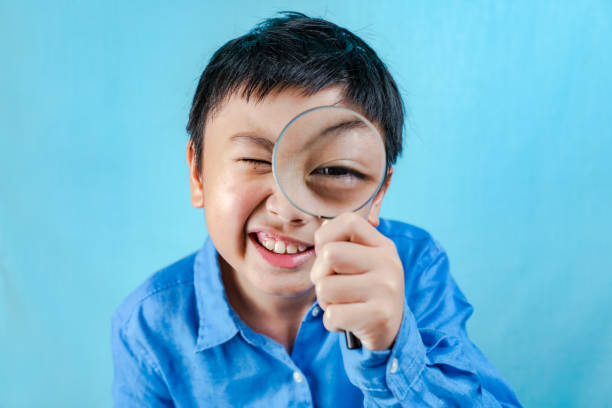 Little boy holding Magnifying glass stock photo