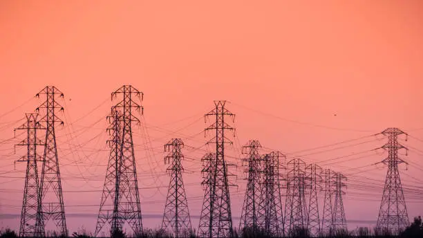 Photo of Sunset view of high voltage electricity towers on the shoreline of San Francisco bay area; California