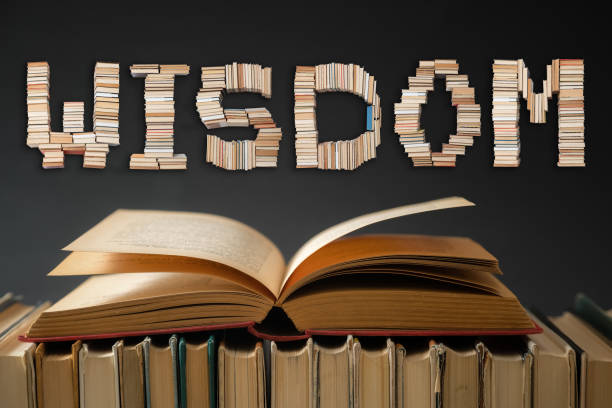 istock Wisdom text and open book on black background. Education and learning. Back to school 1254939314