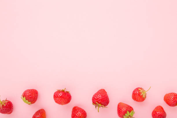 istock Red bright strawberries on light pink table background. Beautiful fresh berries. Pastel color. Flat lay. Empty place for text. Top down view. 1254941387