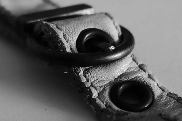 Details of a small leather belt, white and red, and in black and white.