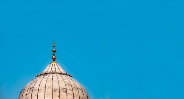 istock An isolated dome structure of mughal architecture with clear blue sky background as empty copy space for text. Design layout and template for Eid festival with a part of Jama Masjid mosque of Delhi. 1254942414