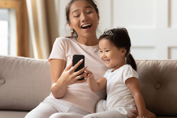 istock Excited vietnamese family using smartphone at home. 1254943689