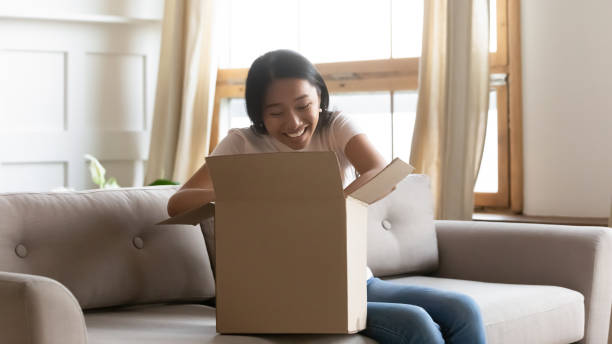 istock Curious asian female client unboxing online order. 1254943761