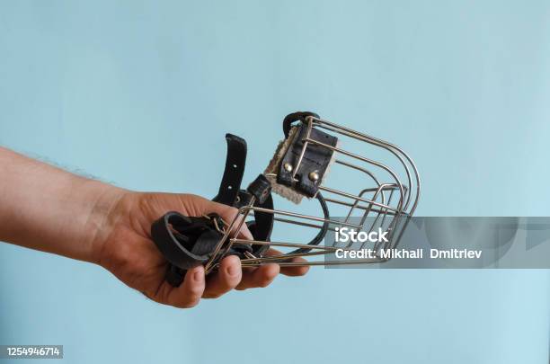 Metal Muzzle With Leather Straps For A Dog In A Male Hand Stock Photo - Download Image Now