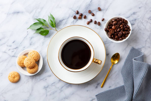 Cup of black coffee with amaretto cookies on marble table. Top view. Cup of black coffee with amaretto cookies on marble table. Top view. decaffeinated photos stock pictures, royalty-free photos & images
