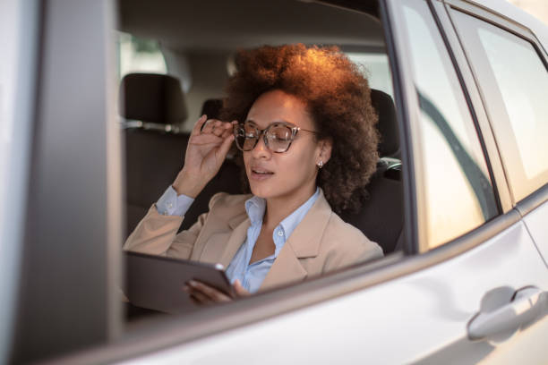istock Business woman using digital tablet in a car 1254947461