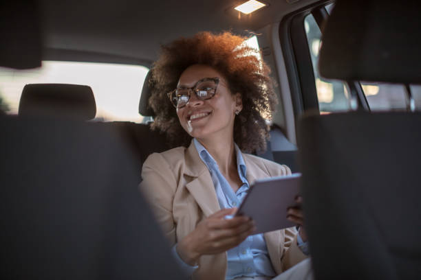 istock Business woman using digital tablet in a car 1254947573
