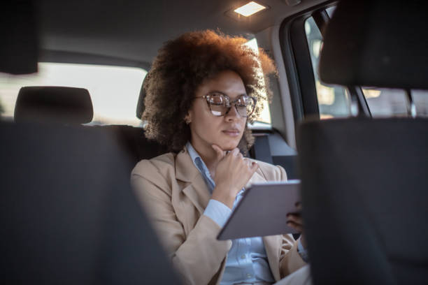 istock Business woman using digital tablet in a car 1254947625