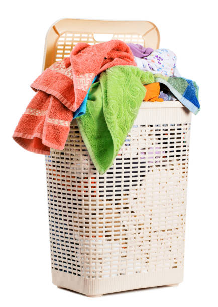 istock Laundry basket full of dirty washing (isolated on white) 1254947698