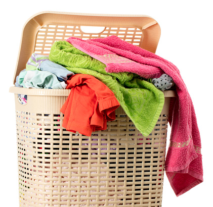 Laundry basket full of clean clothes in room near wall, 3D rendering