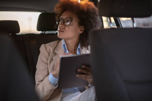 istock Business woman using digital tablet in a car 1254947749