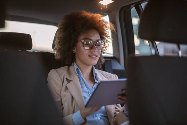istock Business woman using digital tablet in a car 1254947900