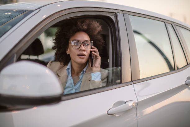 istock Business woman using smart phone in a car 1254948124