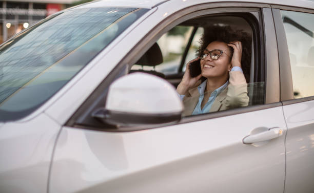 istock Business woman using smart phone in a car 1254949009