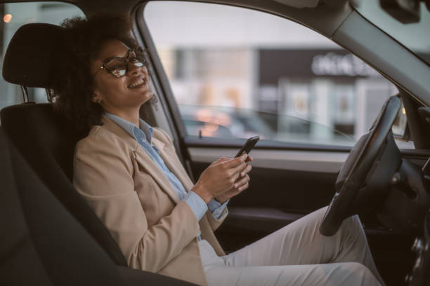 istock Business woman using smart phone in a car 1254949276