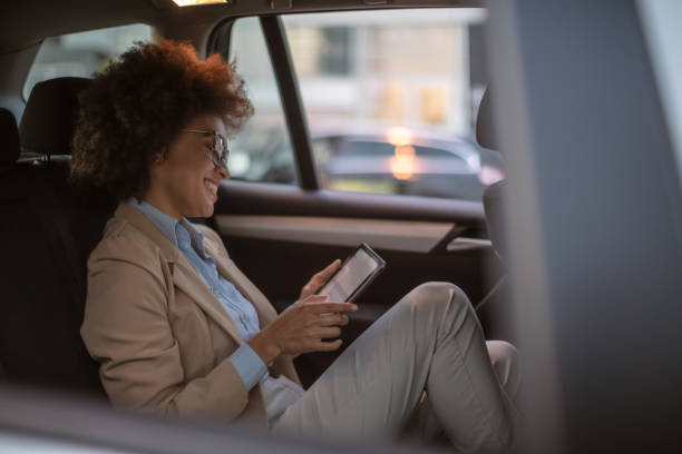 istock Business woman using smart phone in a car 1254949545
