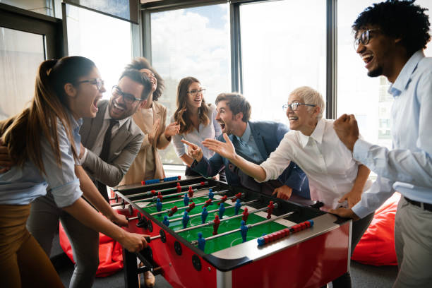 istock Employees playing table soccer indoor game in the office during break time 1254950981