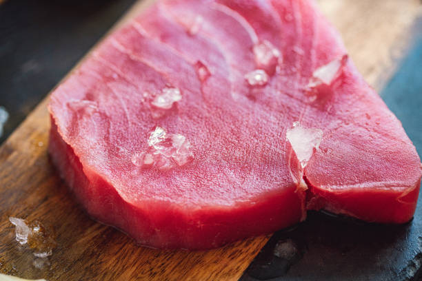 filete de atún crudo con ingredientes en una tabla de cortar - vitamin d salmon fillet raw fotografías e imágenes de stock