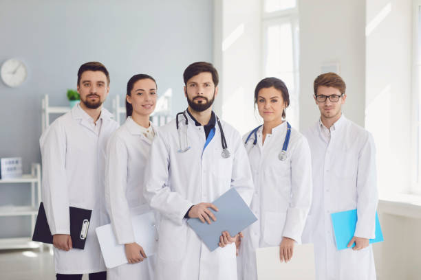 istock A group of confident practicing doctors in white coats are smiling against the backdrop of the clinic. 1254952978