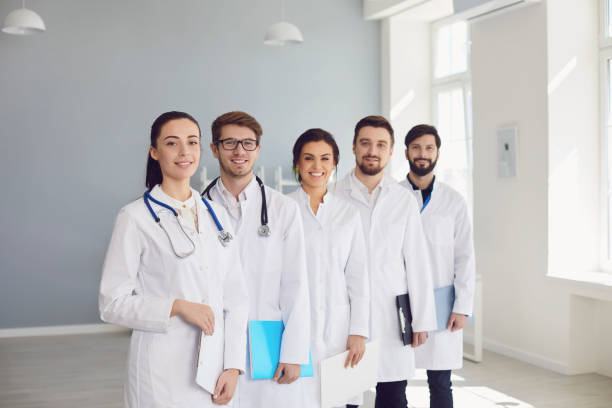 istock A group of confident practicing doctors in white coats are smiling against the backdrop of the clinic. 1254952983