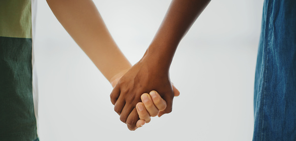 Midsection of unrecognizable caucasian boy and african american girl, holding hands.