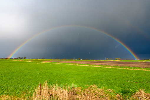 Rainbow during a rain and hail storm over the delta of the river IJssel in Overijssel, The Netherlands near the city of Kampen.