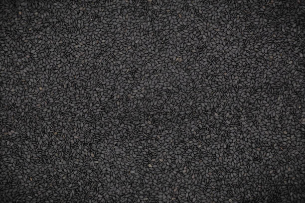 textura y fondo de semillas de sésamo negro, vista superior. - sesame black stack cereal plant fotografías e imágenes de stock