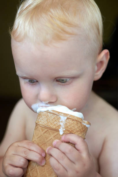 istock Little blue-eyed fair-haired boy eats ice cream. 1254957478