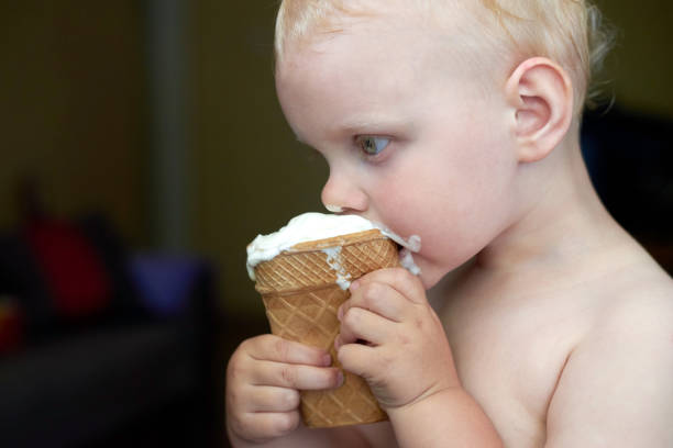 istock Little blue-eyed fair-haired boy eats ice cream. 1254957506