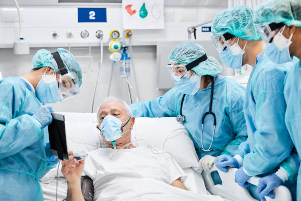 istock Man Looking at Tablet Amidst Doctors And Nurses 1254958351