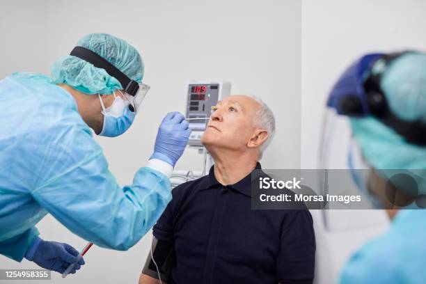 Doctor Taking Coronavirus Sample From Males Nose Pcr Stock Photo - Download Image Now
