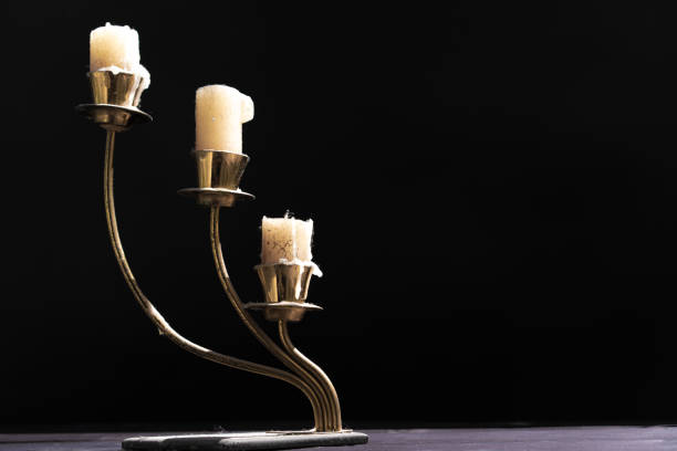 istock Candles in a candlestick on a black background 1254959616
