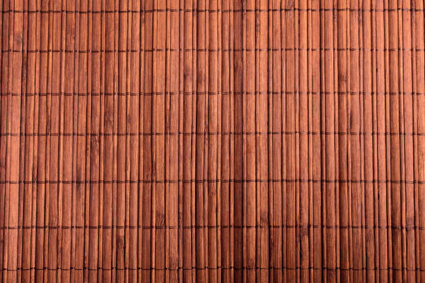 istock Textured bamboo wooden background on a table in warm light, top view 1254959810