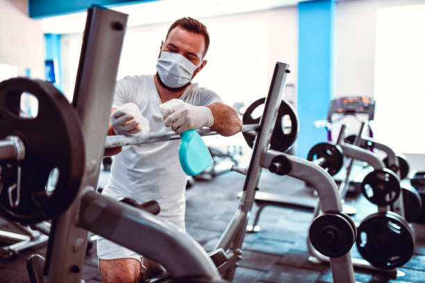 istock Gym Worker Disinfecting Barbell Rack To Prevent Coronavirus Spread 1254961594