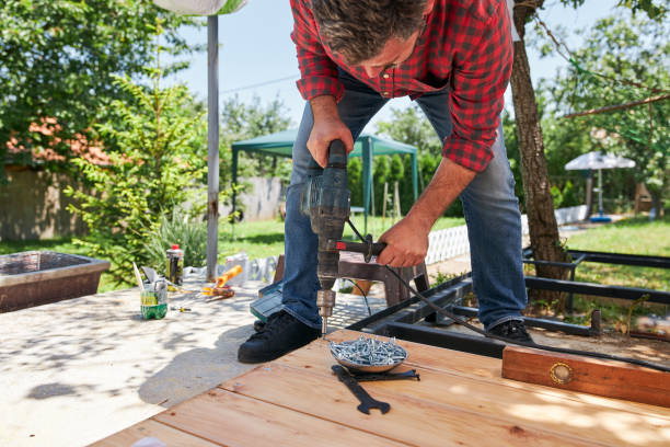 istock Concentrated carpenter using a drill to screw a nail into wooden board 1254961713